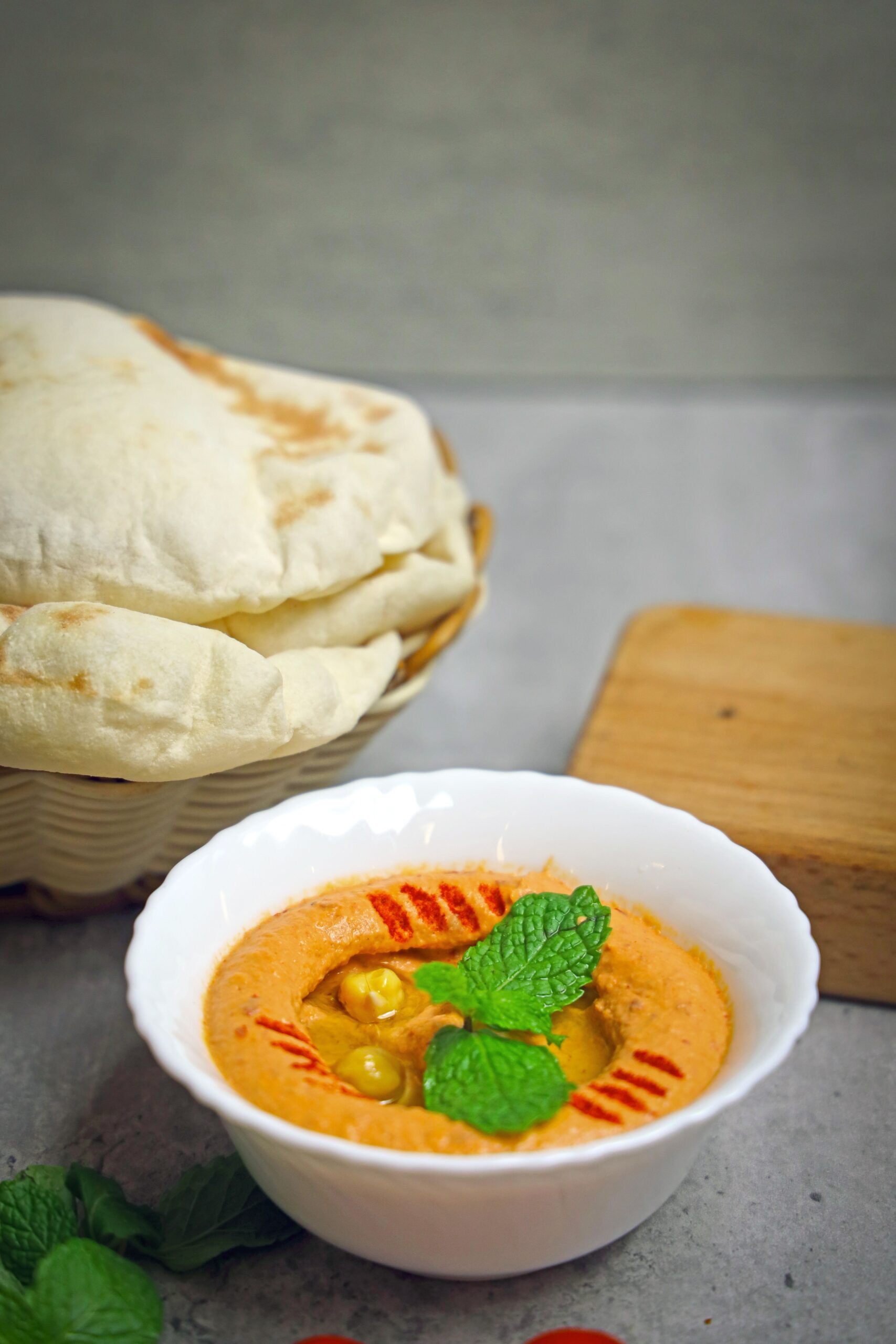 Bol de houmous aux carottes rôties, couleur orangée intense, sur un étal de marché libanais