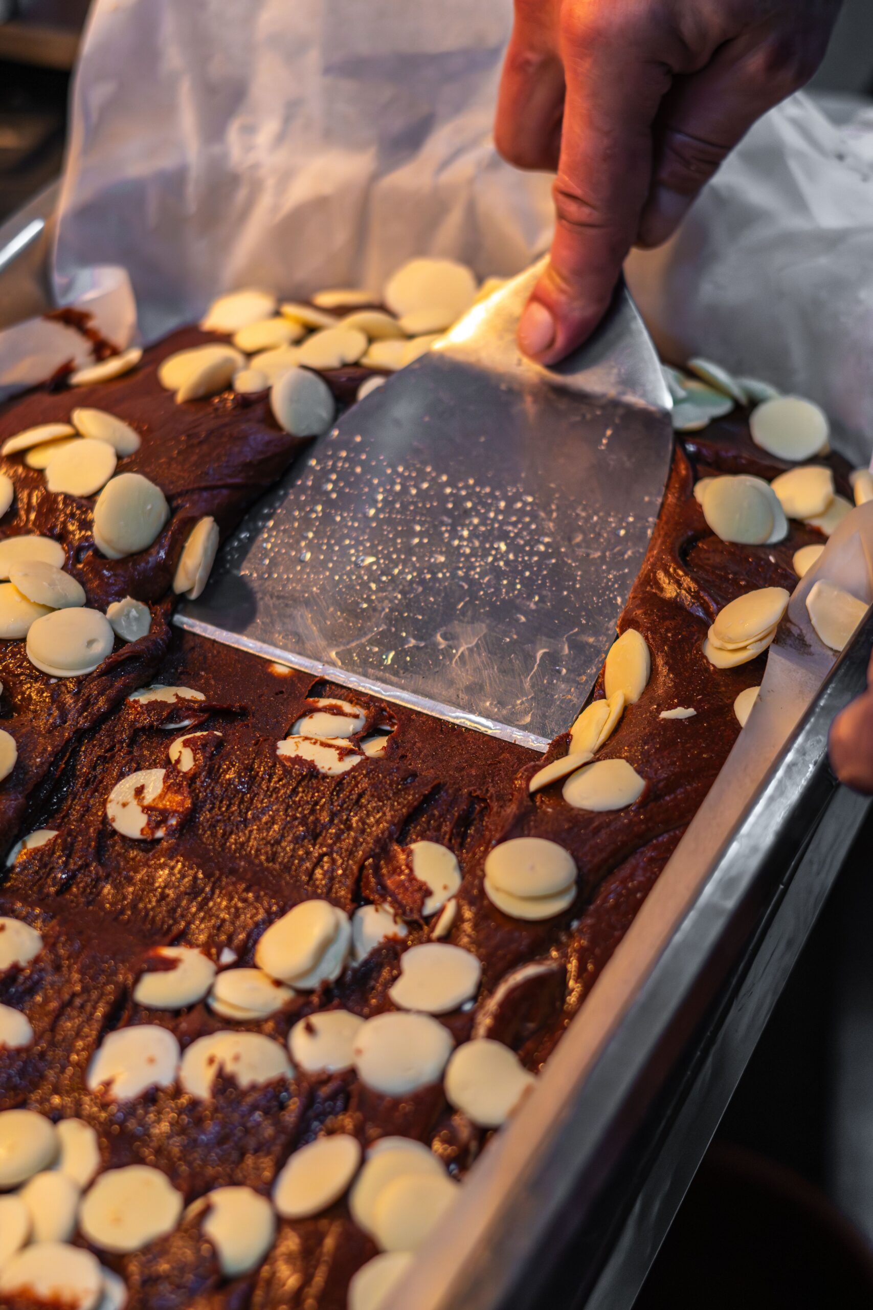 Mains pliant délicatement des pépites de chocolat fondu dans la pâte