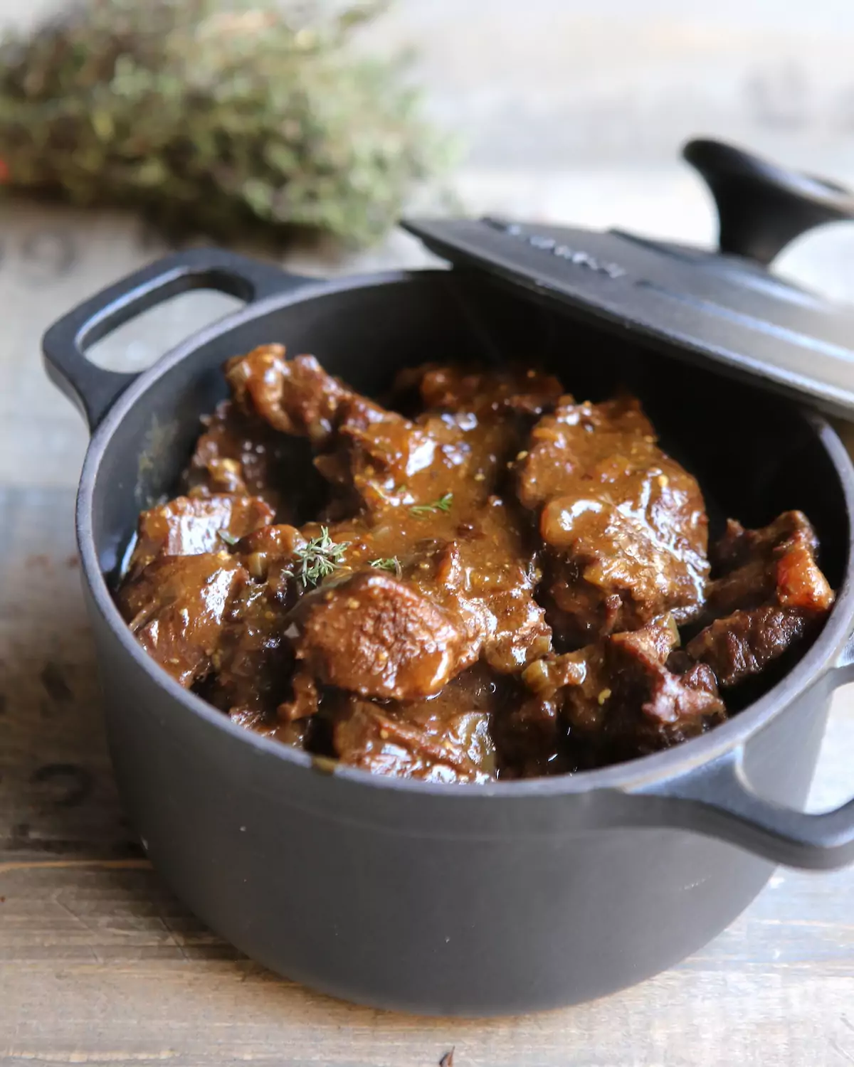 Carbonade flamande fumante servie dans une cocotte en fonte émaillée